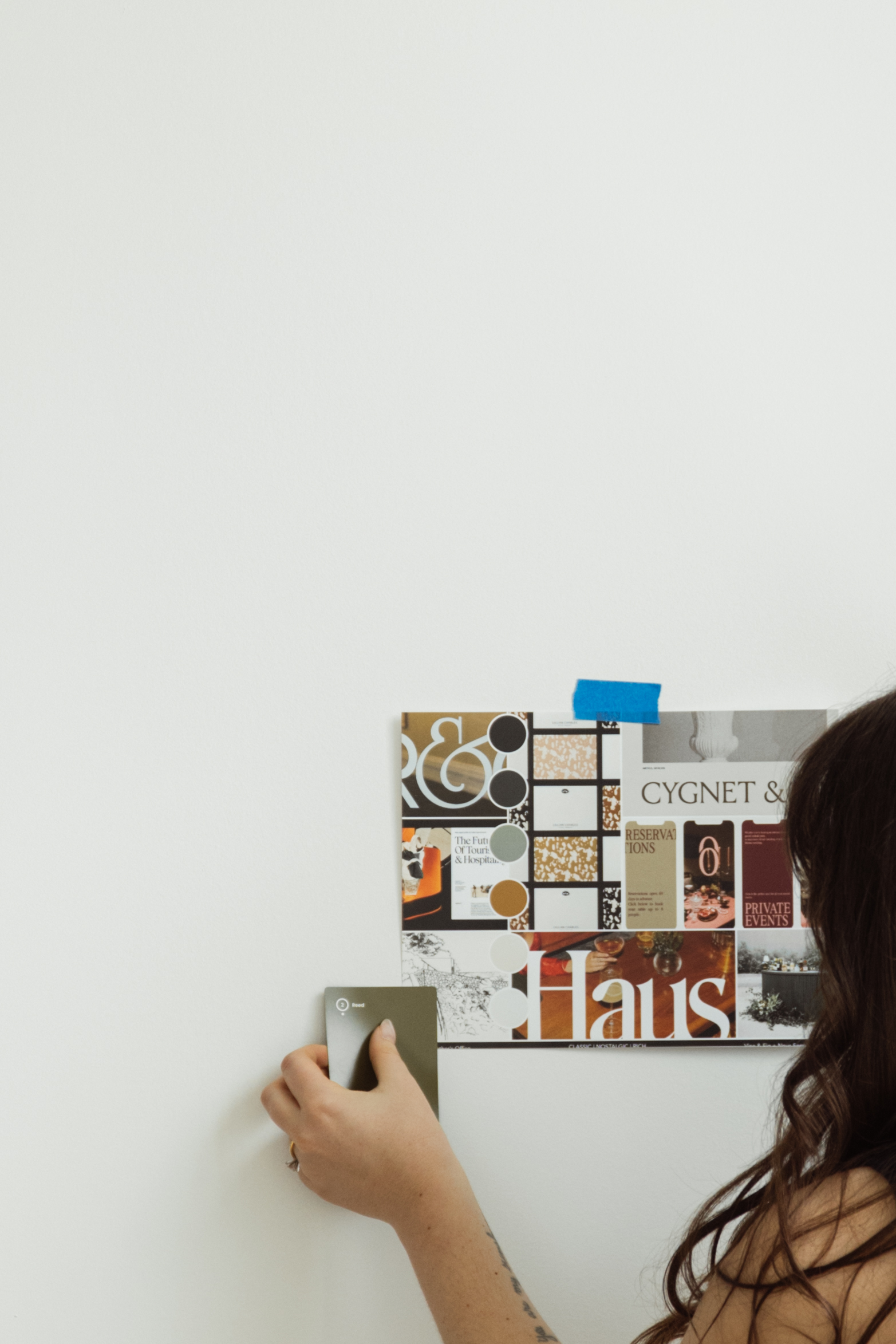 Branding designer taping branding kit inspiration to the wall
