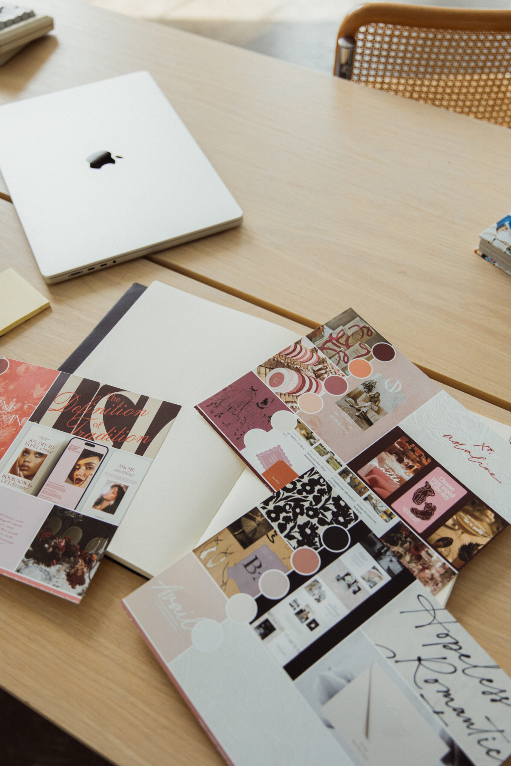 Branding kit inspiration laying on a wooden table - magazines, brand color palettes, and more